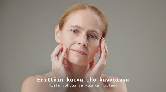 Erittäin kuiva iho kasvoissa teksti edessä. Nainen pitelee harmaan taustan edessä käsillä kasvojaan pää hieman kallellaan.