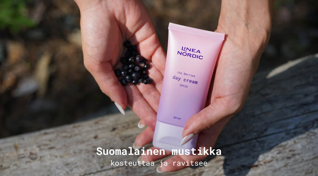 Kädet, jotka pitävät suomalaisia mustikoita sekä päivävoidetta käsissä.