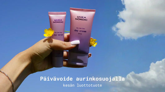 the Berries päivävoide ja päiväseerumi taivasta vasten kädessä keltaiset kukat kädessä myös